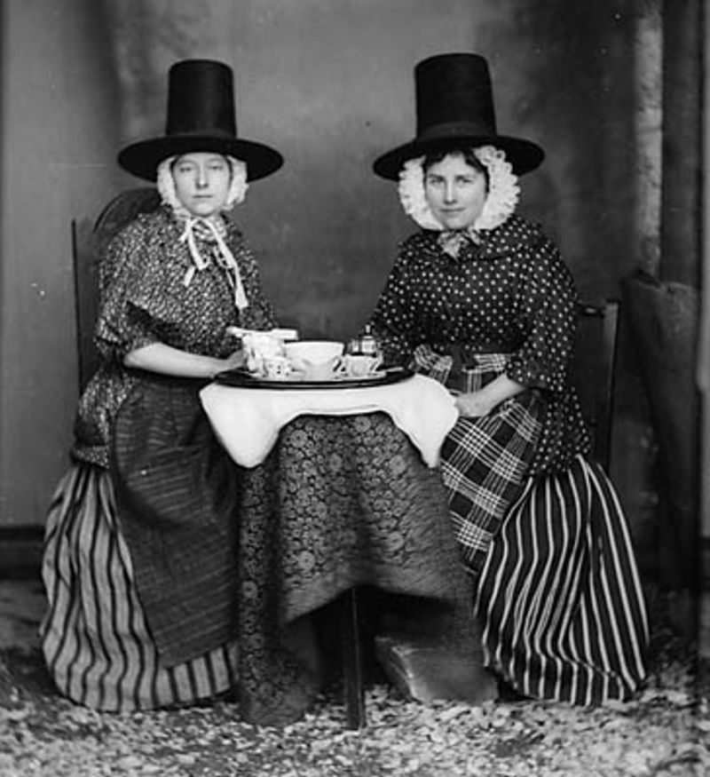 Two women in national dress drinking tea. Thomas, John,, Public domain, via Wikimedia Commons